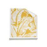 A roll of wallpaper with a yellow and white tropical leaf pattern, shown partially unrolled on a clean white background.