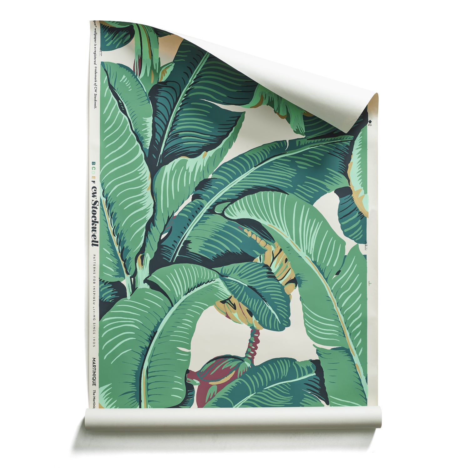 A roll of banana leaf patterned wallpaper in shades of jungle greens on white. 