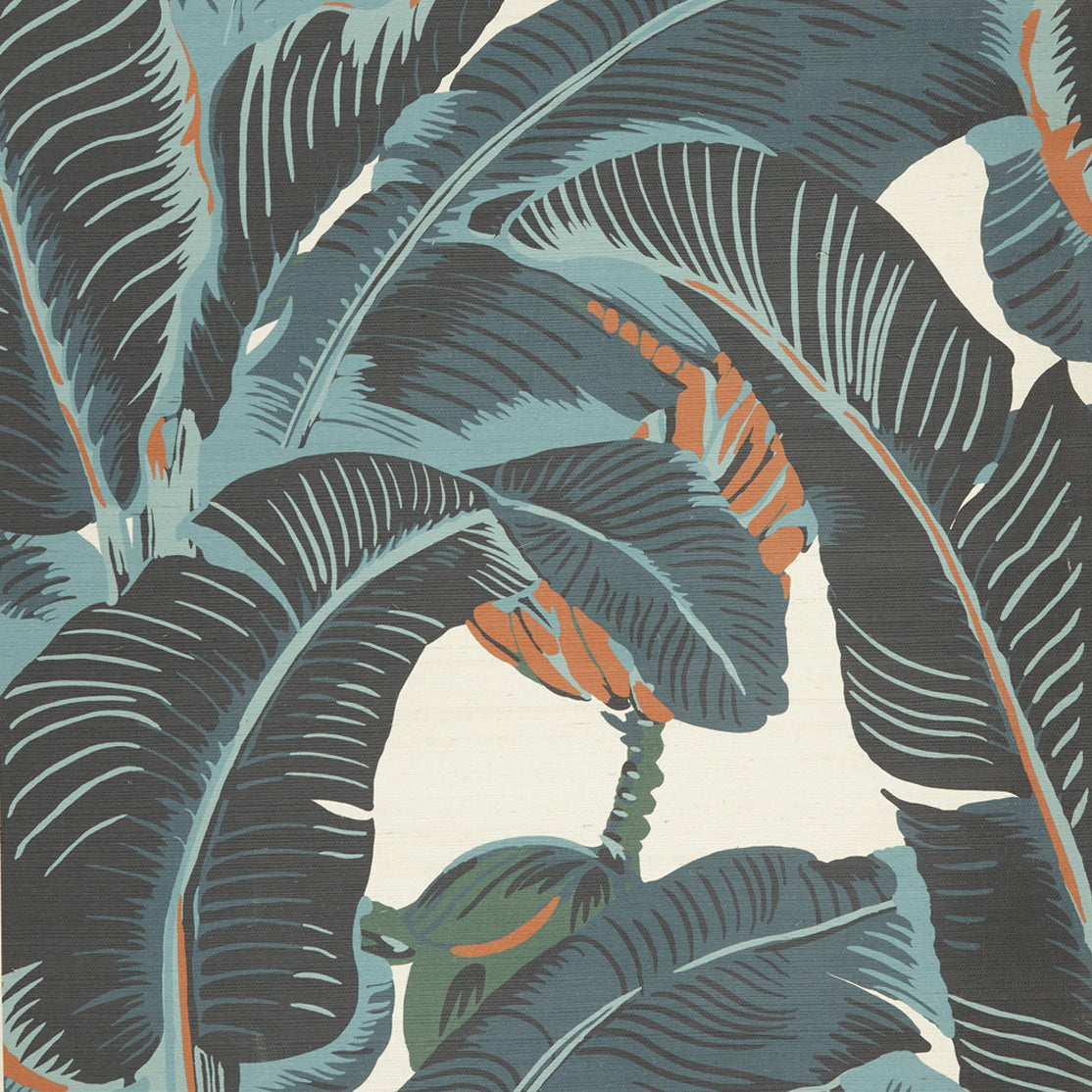 Close up of banana leaf pattern grasscloth wallpaper featuring large tropical leaves in dark charcoal gray, muted teal, and soft orange on an off-white background.