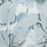 A close-up of a tropical wallpaper pattern featuring large, stylized palm leaves in shades of slate blue-gray and off-white.