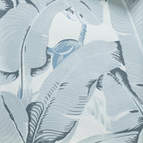 A close-up of a tropical wallpaper pattern featuring large, stylized palm leaves in shades of slate blue-gray and off-white.