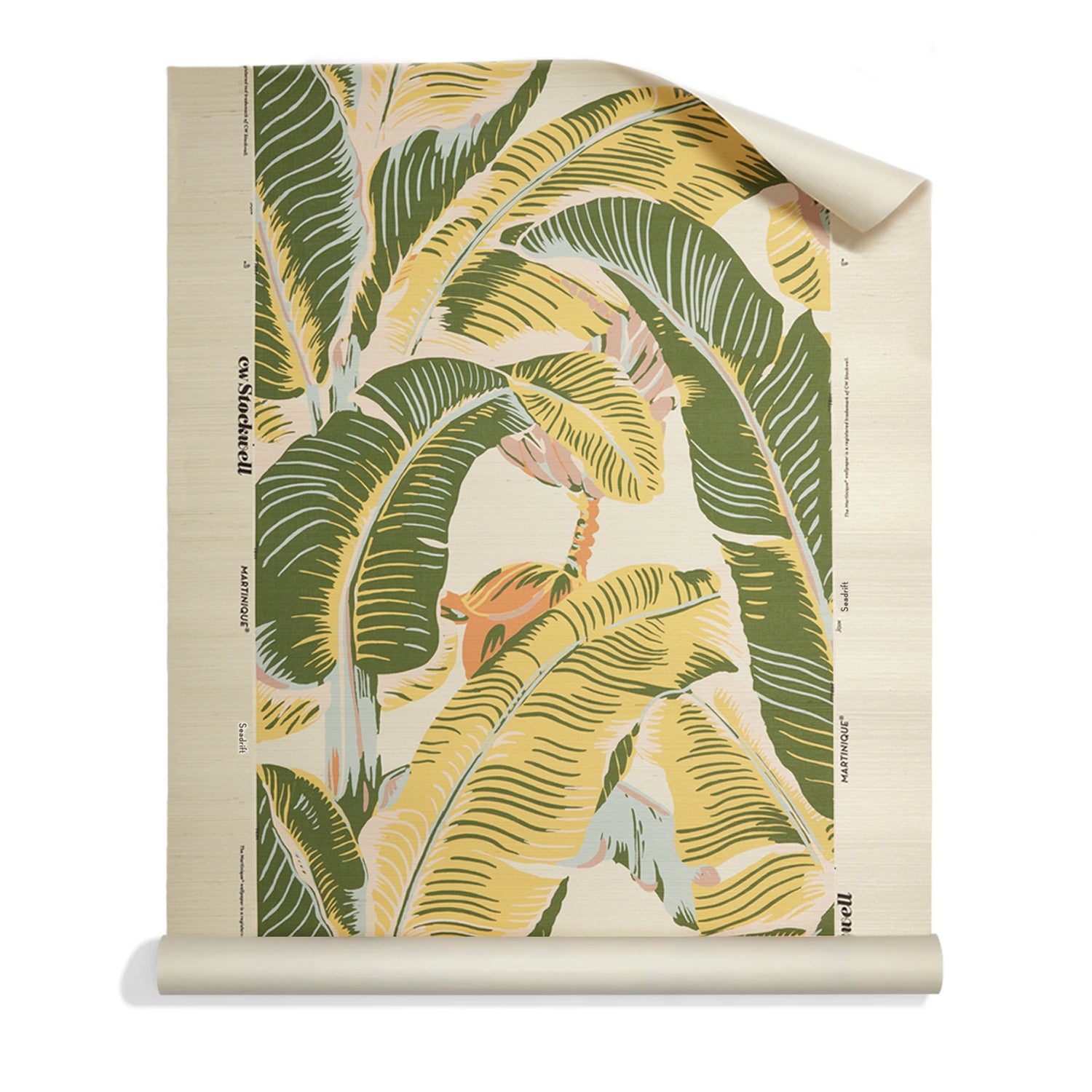 A roll of grasscloth with a tropical banana leaf pattern in shades of green and yellow on a cream background, shown partially unrolled against a white studio background.