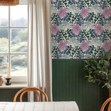 A dining room tableau with a large window and statement wall papered in a large-scale floral print.