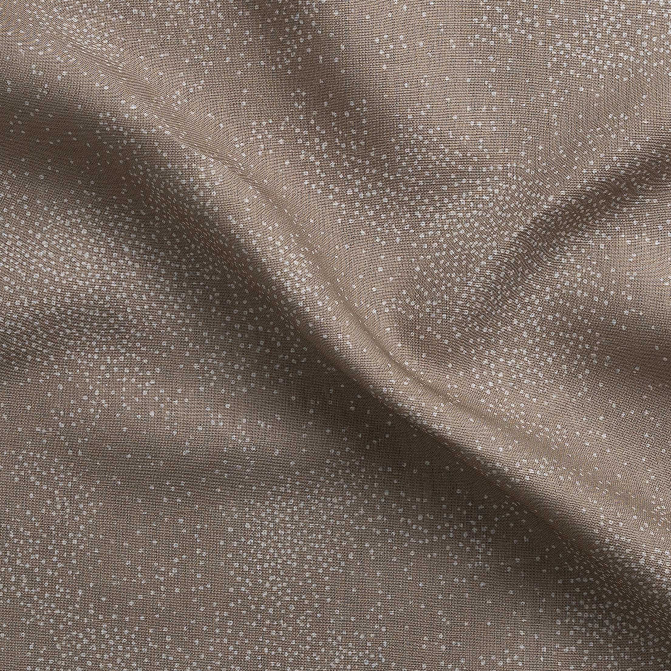 Detail of gently draped printed fabric with a white celestial dotted pattern on a warm beige background. 