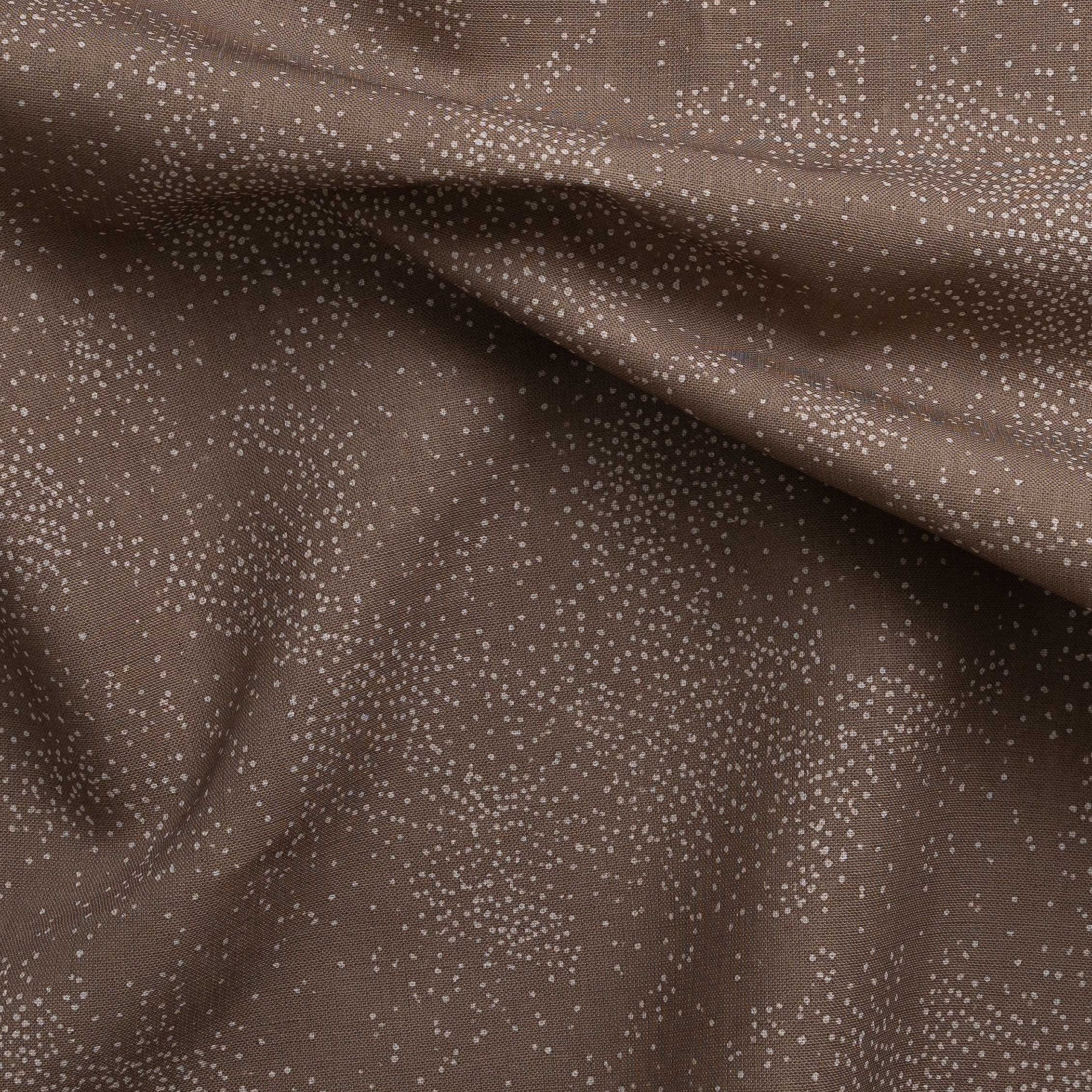 Detail of gently draped printed fabric with a white celestial dotted pattern on a warm clay background. 