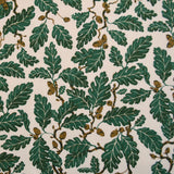 Pattern of green leaves and acorns on a beige background