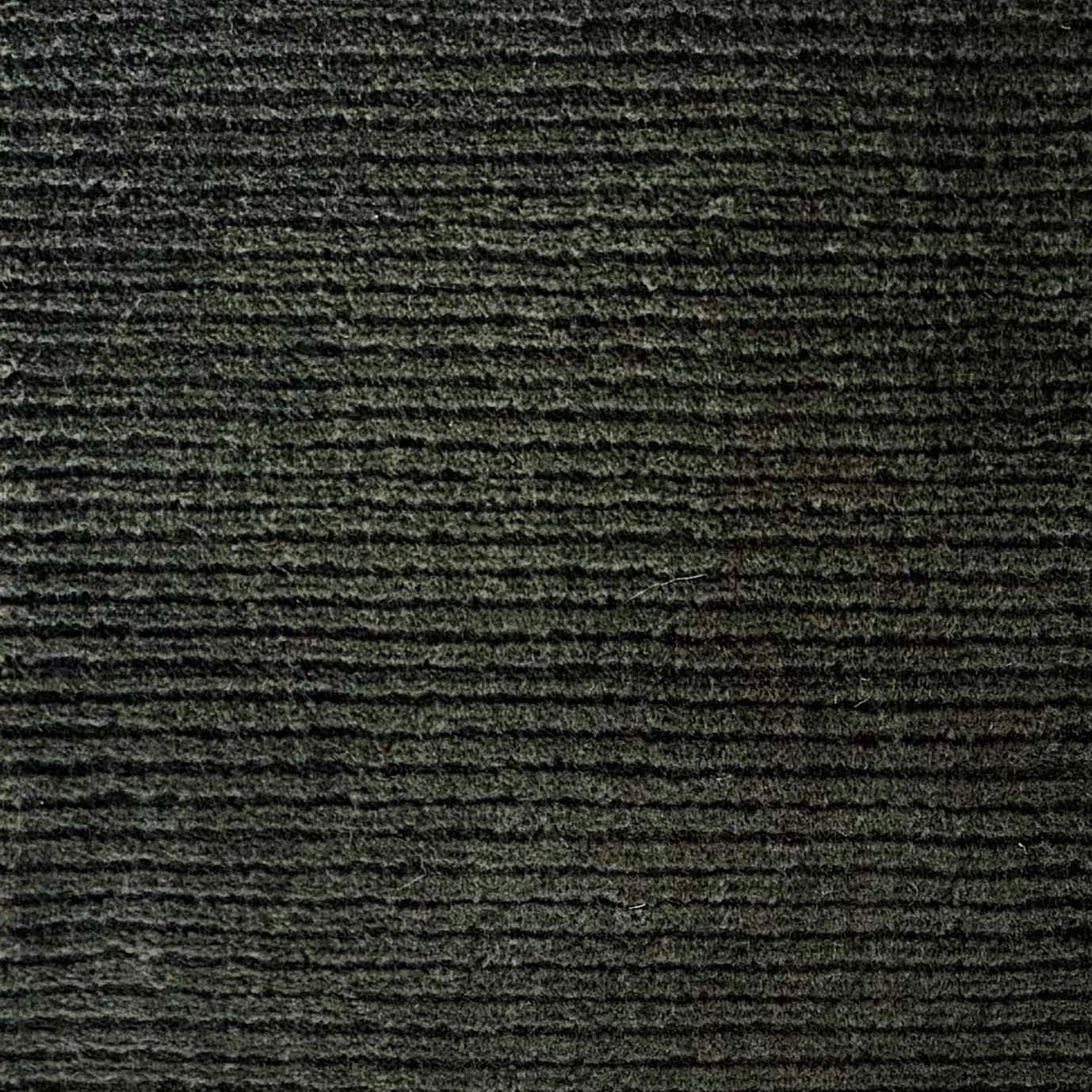 Close up of broadloom carpet with solid cut pile ribbed stripe in dark green.