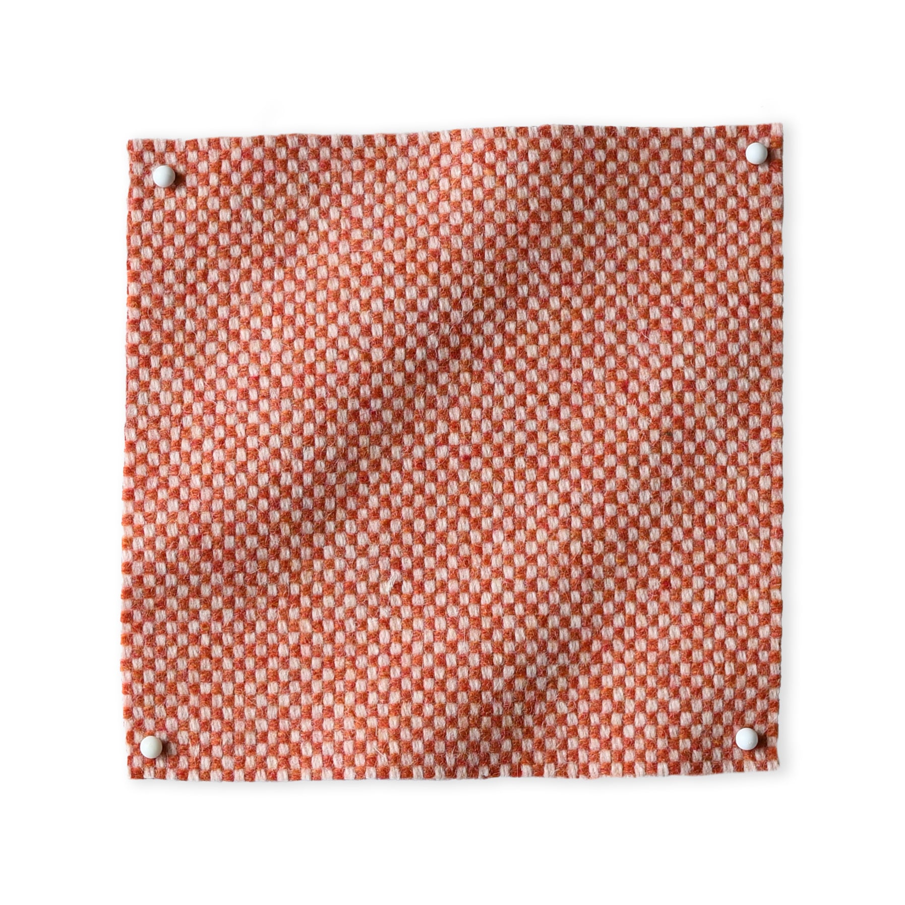 Pinned swatch of woven fabric in orange.