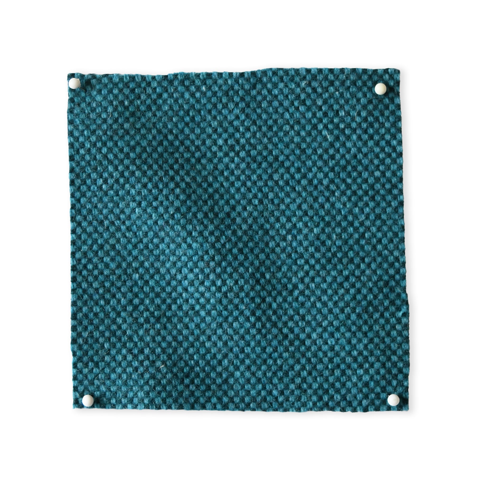 Pinned swatch of woven fabric in teal