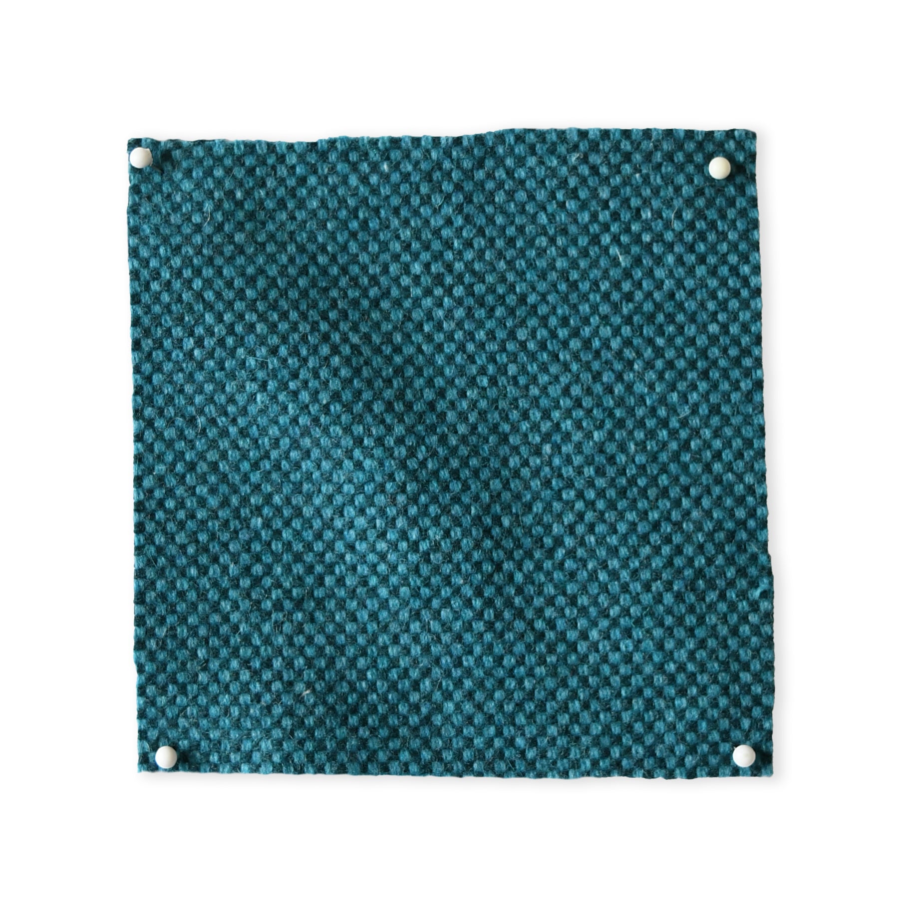 Pinned swatch of woven fabric in teal