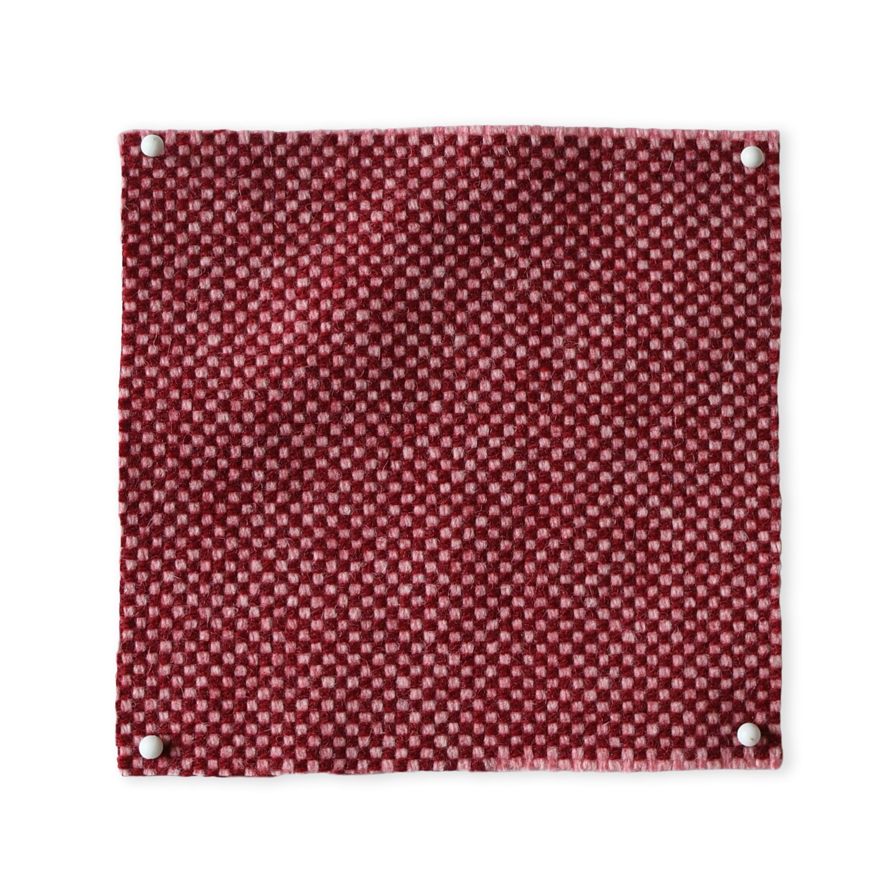 Pinned swatch of woven fabric in red. 