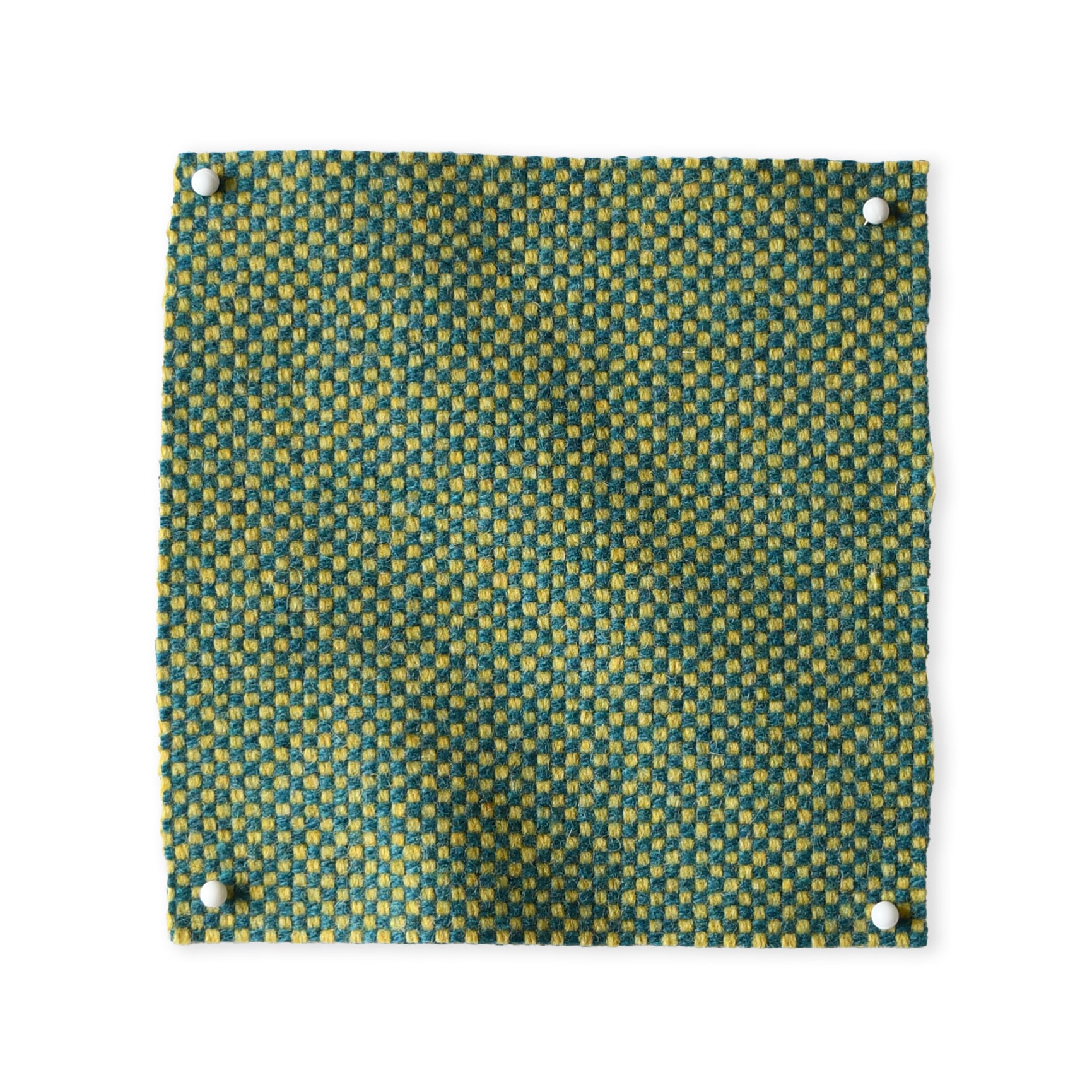 Pinned swatch of woven fabric in green and teal.