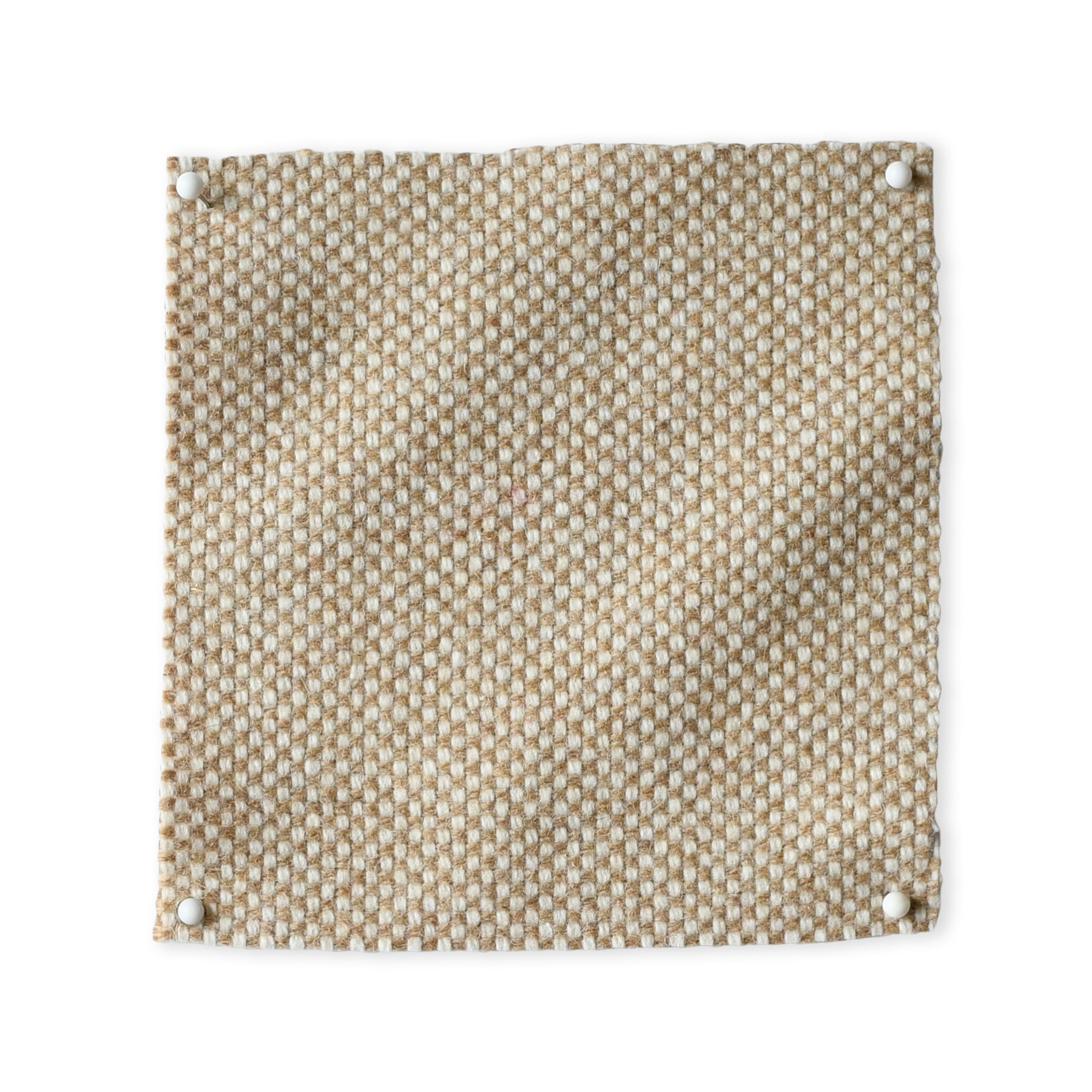 Pinned swatch of woven fabric in beige. 