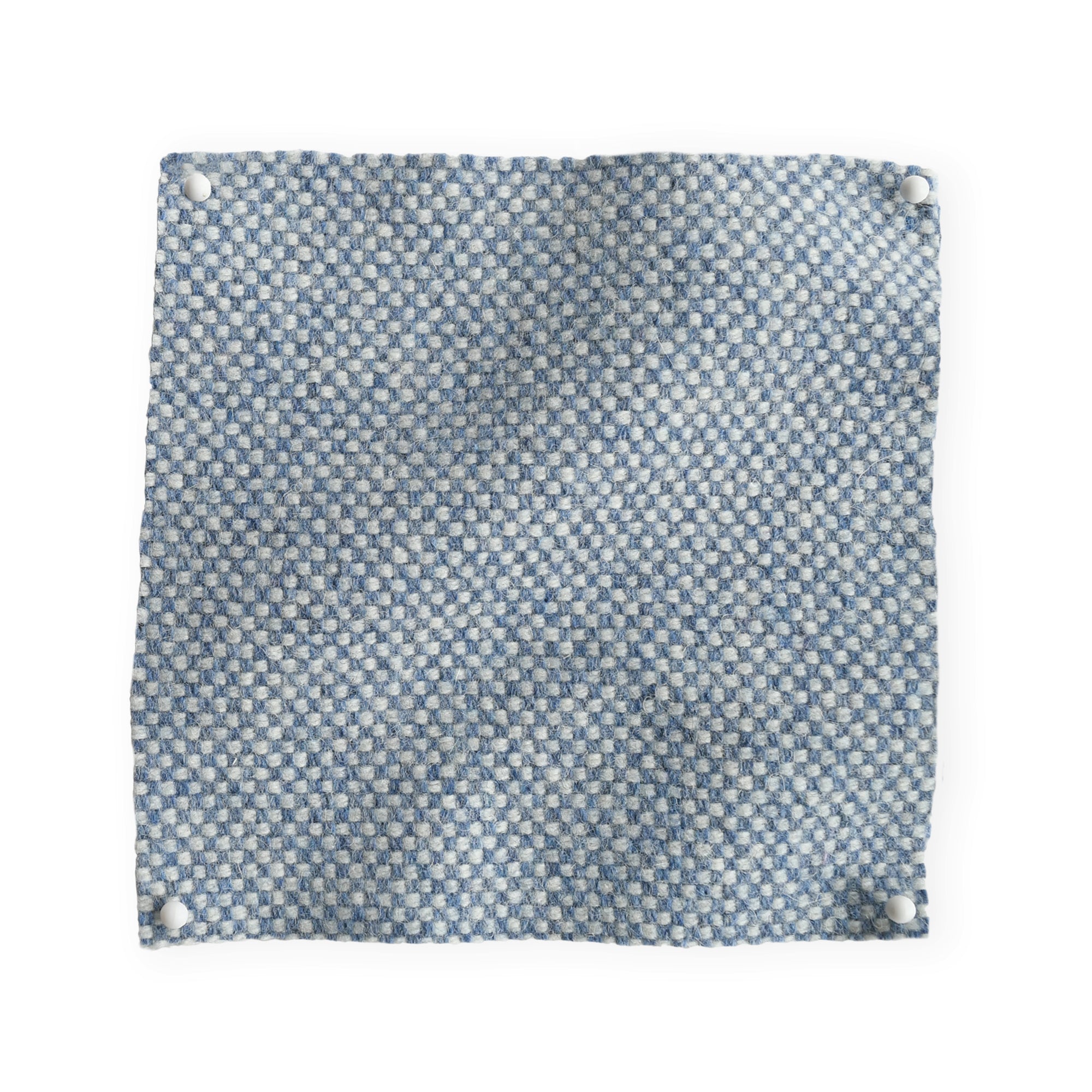 Pinned swatch of woven fabric in pale blue. 
