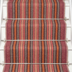 Striped flatweave runner in orange black red on white staircase