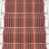 Striped flatweave runner in orange black red on white staircase