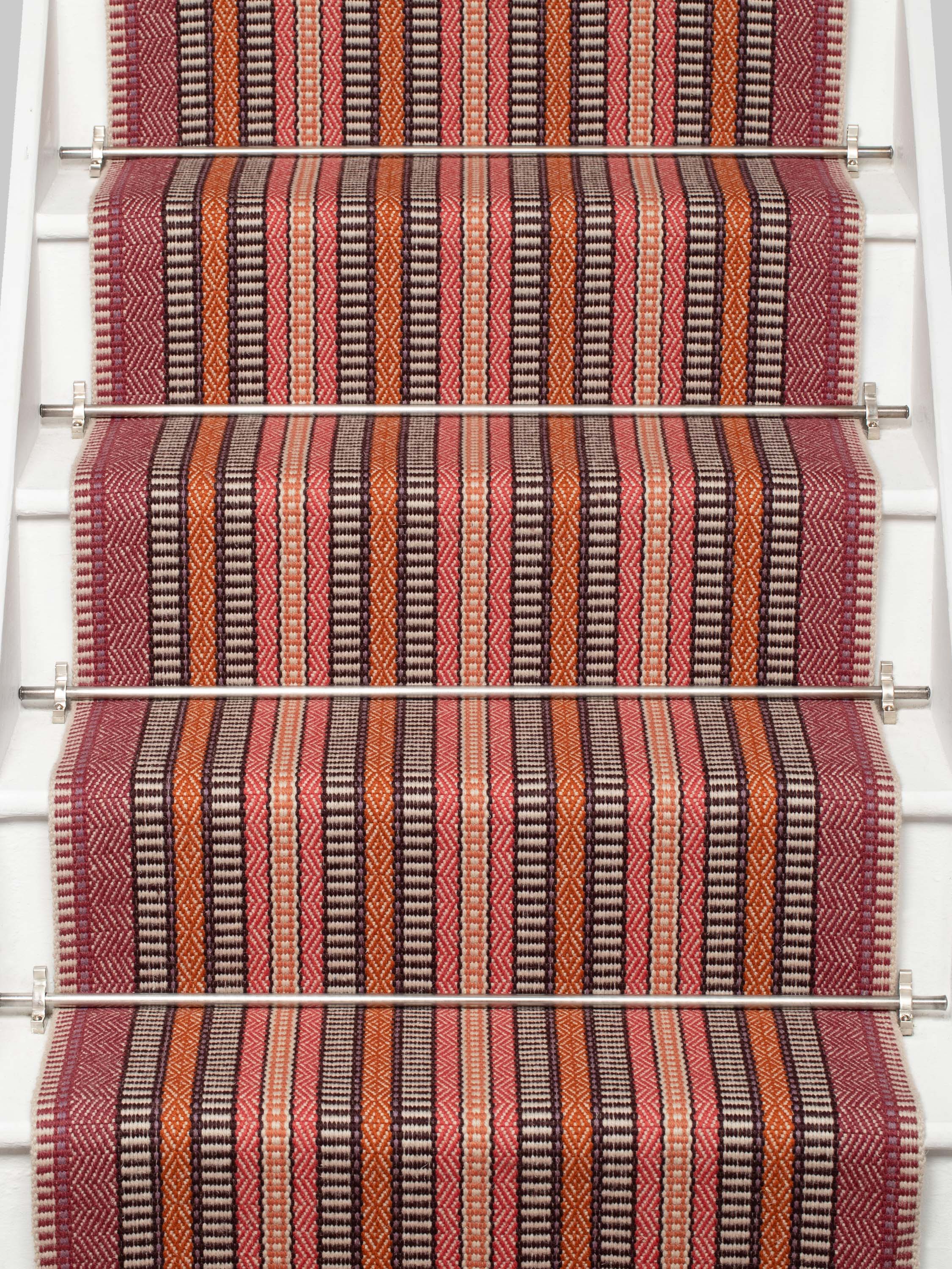 Striped flatweave runner in orange black red on white staircase
