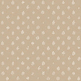 Detail of fabric in a repeating leaf print in cream on a tan field.