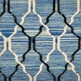 Detail of flatwoven rug with a black and white lattice design over a mottled blue ground