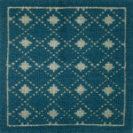 Handmade rug with classic diamond lattice design in teal with cream accents. 