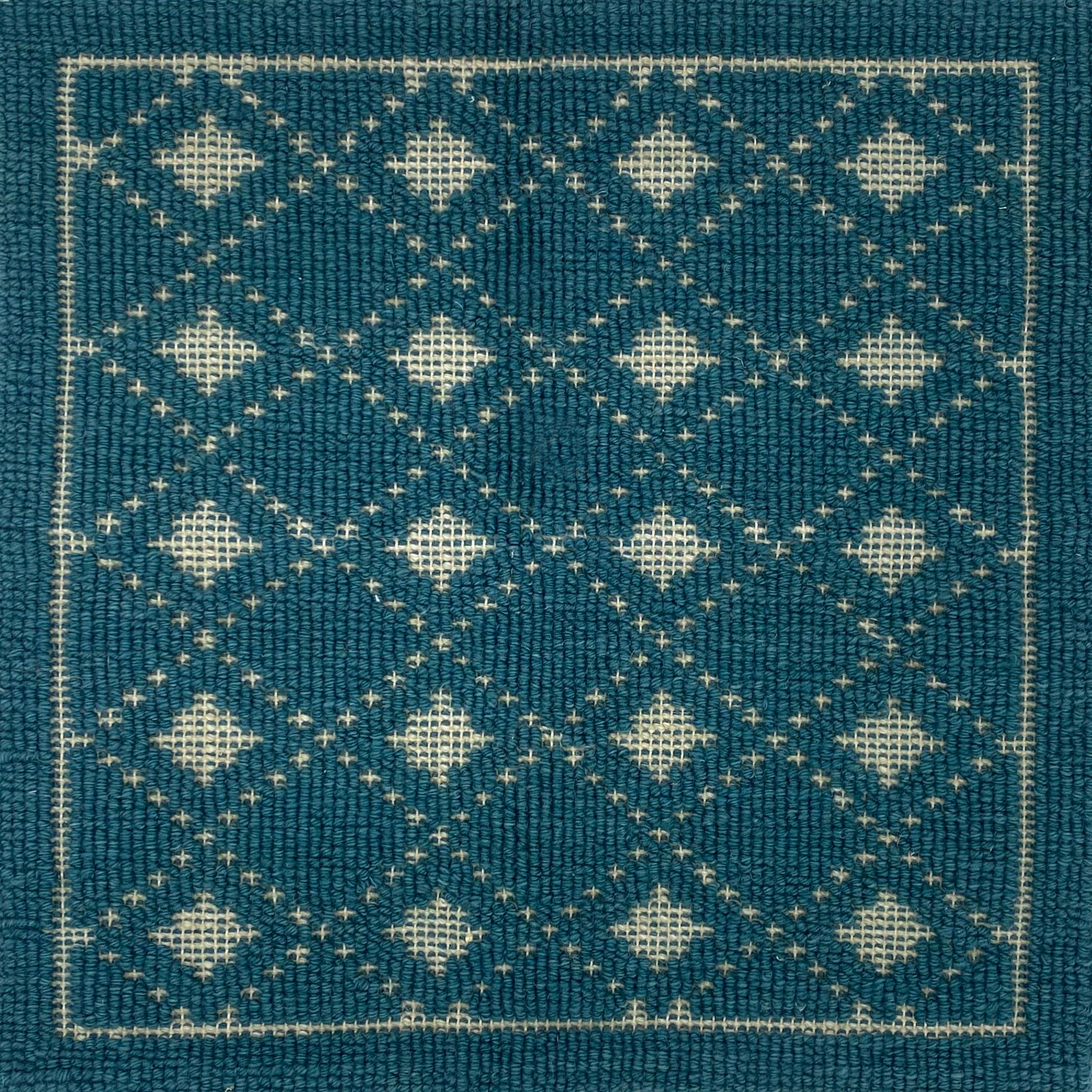 Handmade rug with classic diamond lattice design in teal with cream accents. 
