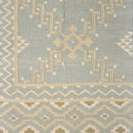 Patterned rug with geometric design on a light blue background