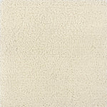 A close-up texture shot of a handtufted rug, showing the cut pile texture in a solid cream color.