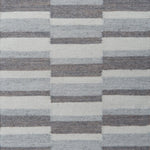 Flatweave rug in a broken stripe in shades of grey and cream.