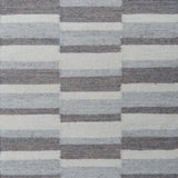 Flatweave rug in a broken stripe in shades of grey and cream.