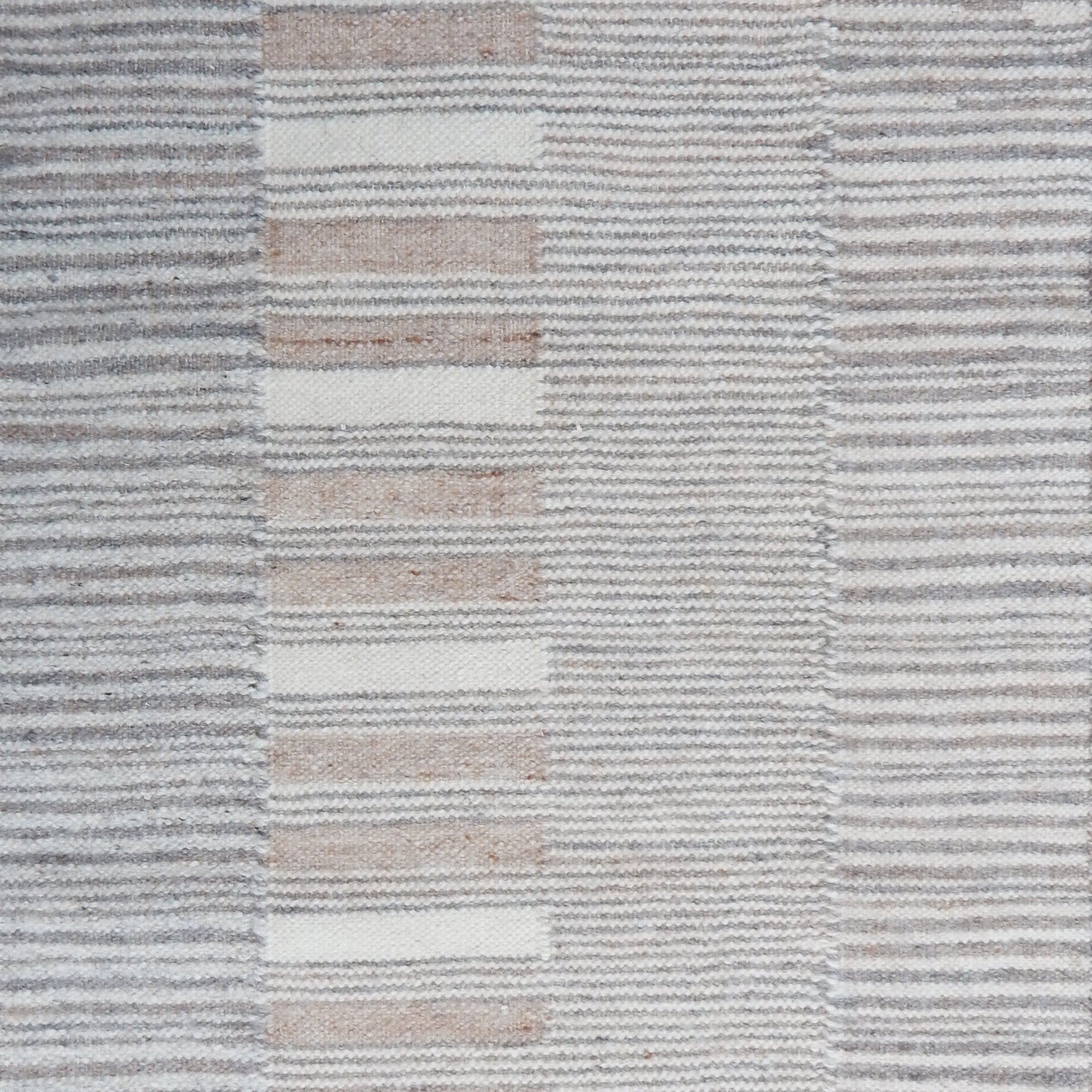 Flatweave rug in a broken stripe in grey, cream and taupe. 