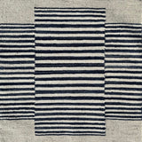 Flatweave rug in with a color central broken stripe in black and white on a beige field. 