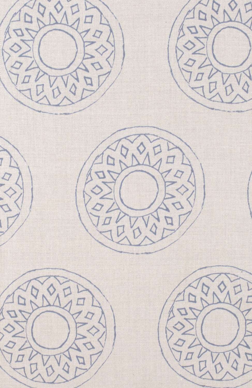 Detail of fabric in a repeating circular geometric print in blue on a cream field.