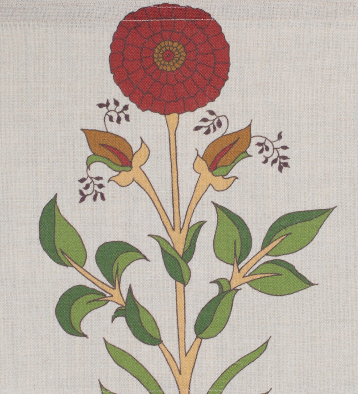 Detail of fabric in a large-scale marigold print in red, green and orange on a cream field.