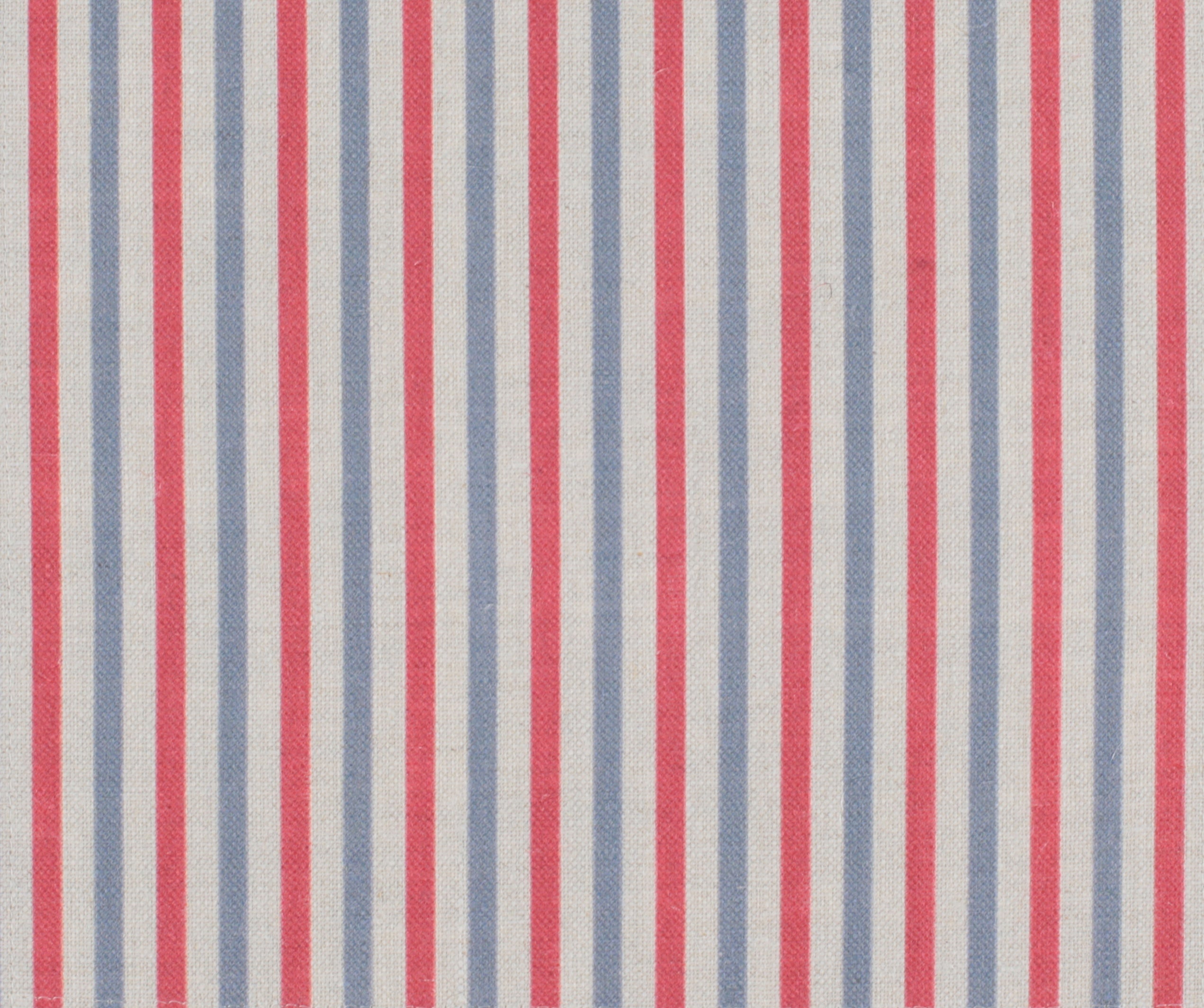 Detail of fabric in a small-scale stripe print in red and blue on a cream field.