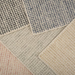 Stack of broadloom carpet samples in a checkered pattern in a range of colors. 