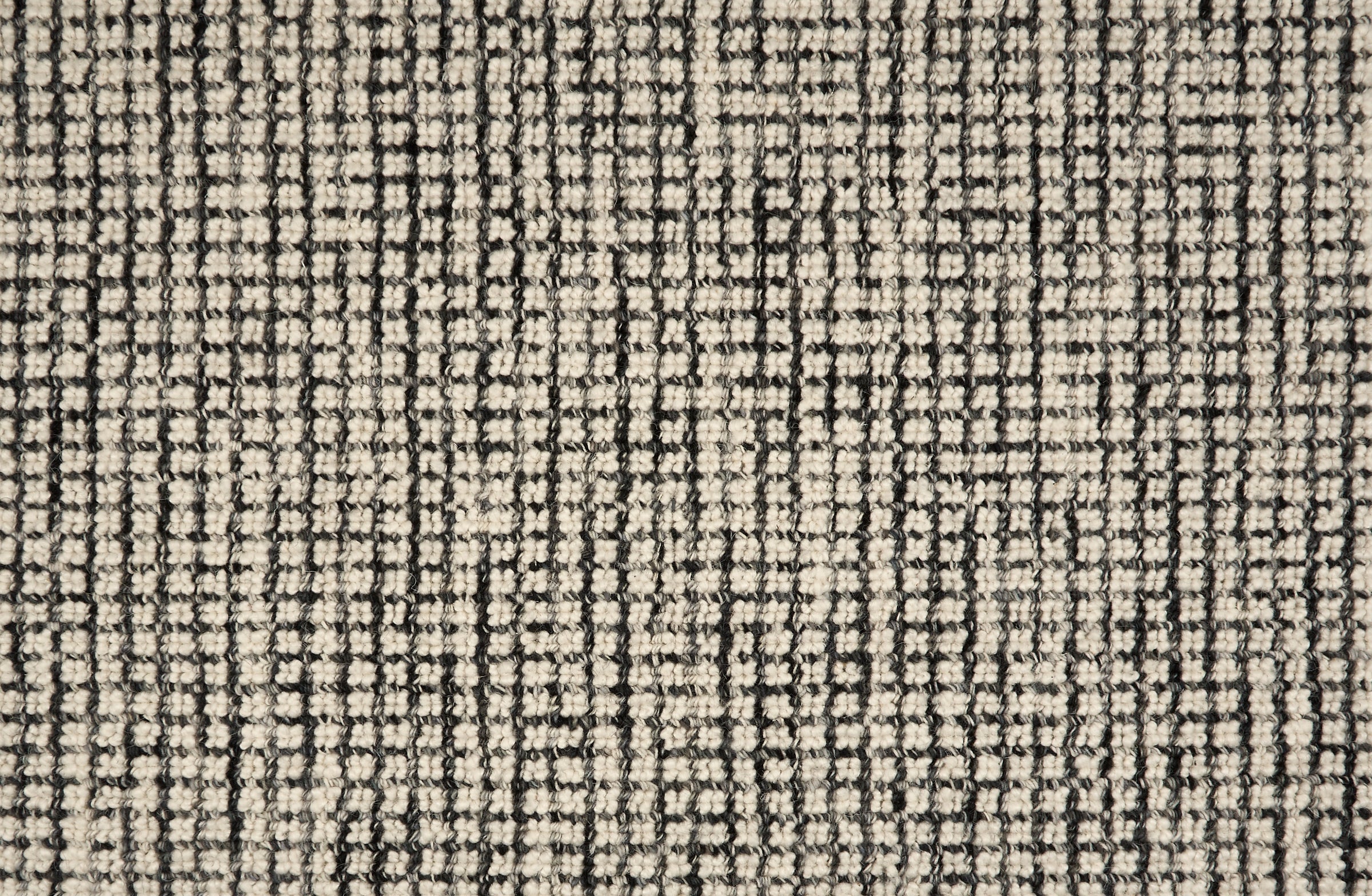 Broadloom carpet in a textural checkered pattern in ivory and strie black. 