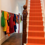 Striped flatweave runner in orange on white staircase