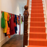 Striped flatweave runner in orange on white staircase