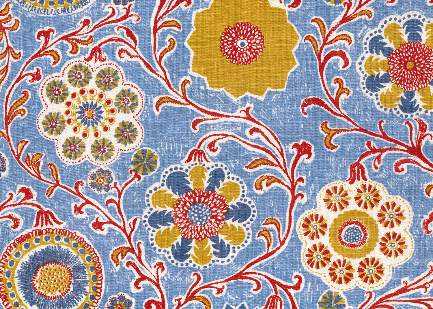 Printed linen in a handdrawn playful floral design in red, yellow, green and blue on a light blue field.