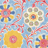 Wallpaper in a handdrawn playful floral design in red, yellow, green and blue on a light blue field.