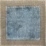 Handloomed rug with neutral border and raised cut pile shag field in aqua blue.