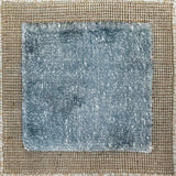 Handloomed rug with neutral border and raised cut pile shag field in aqua blue.