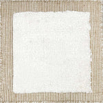 Handloomed rug with neutral border and raised cut pile shag field in white.