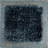Handloomed rug with blue-tan border and raised cut pile shag field in midnight blue.