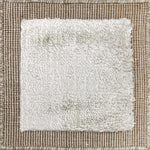 Handloomed rug with neutral border and raised cut pile shag field in grey. 
