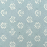 Detail of wallpaper in a playful repeating floral print in cream on a light blue field.
