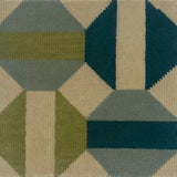 Close-up of a geometric patterned rug with green, blue, and beige colors.