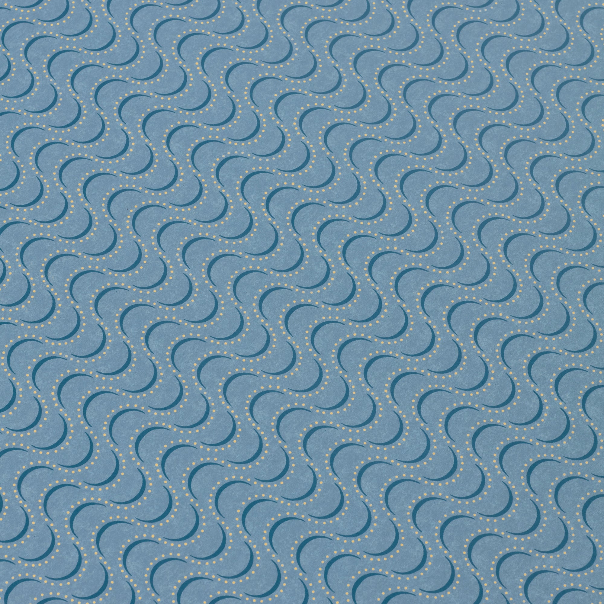 Detail of a wallpaper panel in an undulating stripe pattern in yellow and navy on a blue field.