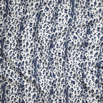Close up of gently draped Indoor-Outdoor fabric with a painterly animal print in dark blue on white. 