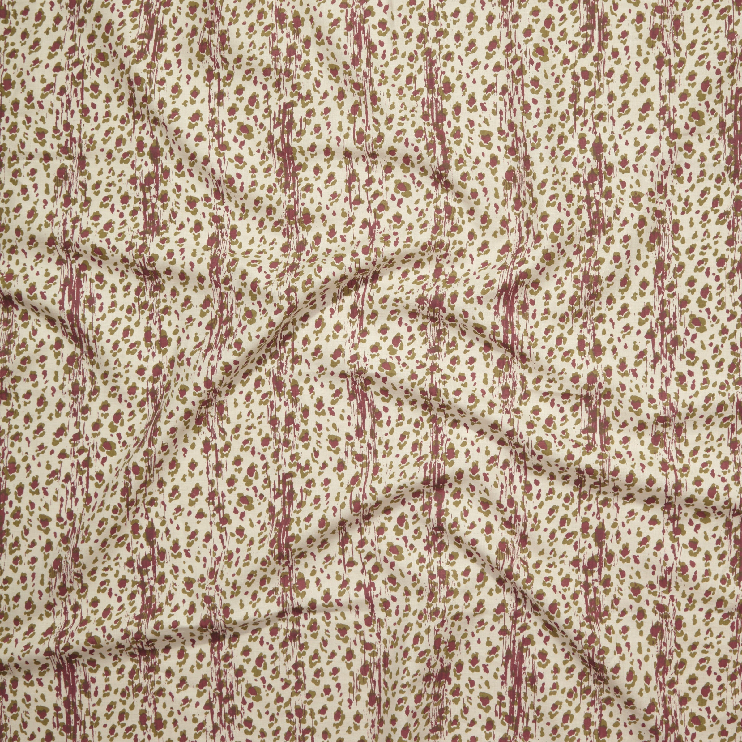 Close up of gently draped printed linen with small scale painterly animal print in mauve and olive green on a beige background